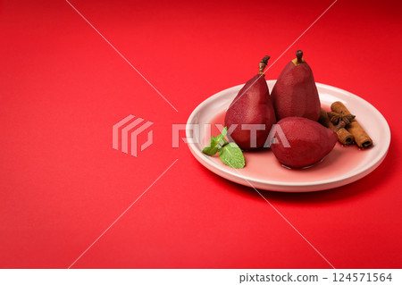 Pears in wine on plate on red background, space for text Pears in wine on plate on red background, space for text 124571564