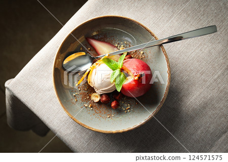 Ice cream and pear in wine on plate and spoon on light background, top view 124571575