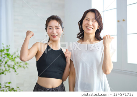 Two women in yoga wear doing fist pumps Two women in yoga wear doing fist pumps 124571732