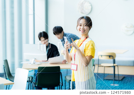 A young woman operating a smartphone in the office 124571980
