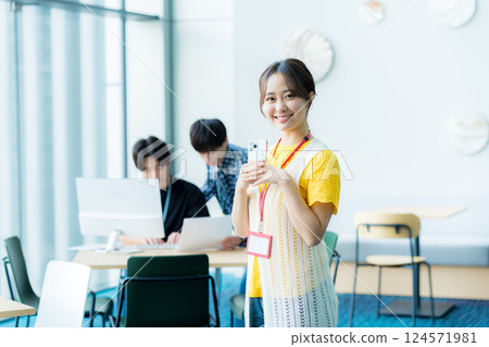操作一個智能手機的少婦在辦公室 操作一個智能手機的少婦在辦公室 124571981