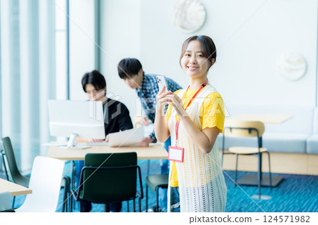 操作一個智能手機的少婦在辦公室 操作一個智能手機的少婦在辦公室 124571982