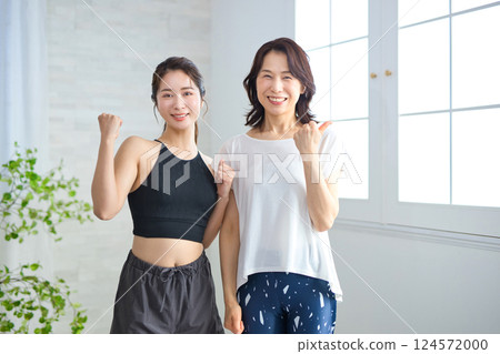 Two women in yoga wear doing fist pumps Two women in yoga wear doing fist pumps 124572000