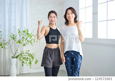 Two women in yoga wear doing fist pumps 124572001