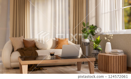 The laptop and coffee cup place on square wooden table in front of leather sofa. Earth tone interior 124572061