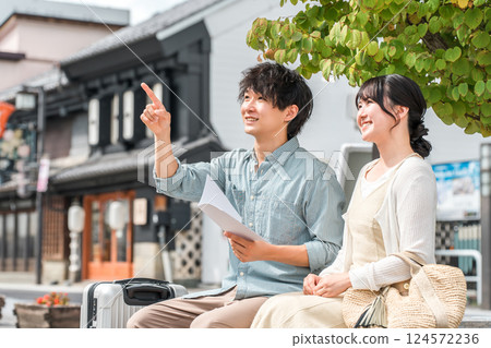 A young couple looking at a guidebook and going on a city walk and sightseeing tour on a domestic trip 124572236
