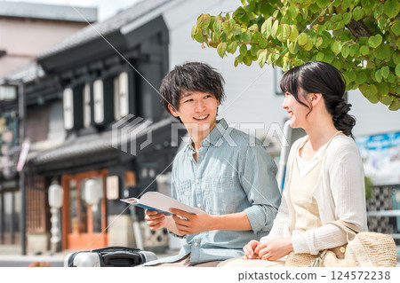 A young couple looking at a guidebook and going on a city walk and sightseeing tour on a domestic trip 124572238