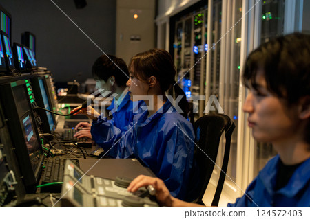 Staff working in a broadcasting station's control room 124572403