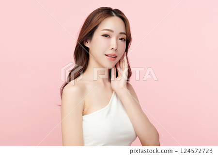 A beautiful young Asian woman with clean, fresh skin against a pink background. Skincare, facial treatment, cosmetology, beauty, and spa. An elegant portrait of an Asian woman. 124572723