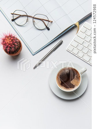 Office worker desk with coffee, cactus, pen, eyeglasses, and keyboard on white background 124572988
