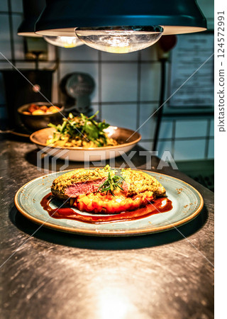 Grilled filet with arugula and tomatoes on a plate, top view vegatables Haute Quisine 124572991
