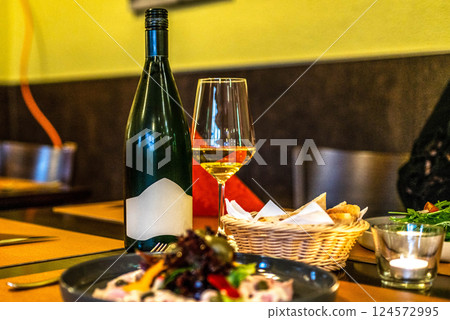 delicious romantic Gala dinner table setting with bottle glass of wine, laid table, side view food porn delicious romantic Gala dinner table setting with bottle glass of wine, laid table, side view food porn 124572995
