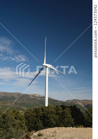 Against the background of the blue sky, a windmill 124573042