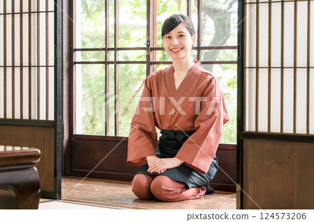 Female inn staff, maid and landlady greeting guests in guest rooms Female inn staff, maid and landlady greeting guests in guest rooms 124573206