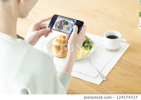 Diet: A woman taking pictures of food with her smartphone 124574537