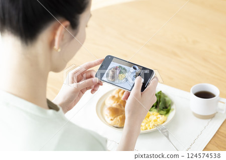 飲食:一名女子用智慧型手機拍攝食物照片 飲食:一名女子用智慧型手機拍攝食物照片 124574538