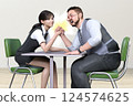 A male and female employee are arm wrestling in the office 124574625