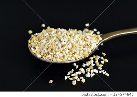 Ground yellow barley grains. 124574645