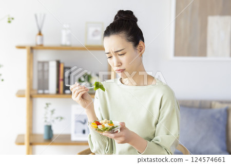 A woman who is tired of eating salad A woman who is tired of eating salad 124574661