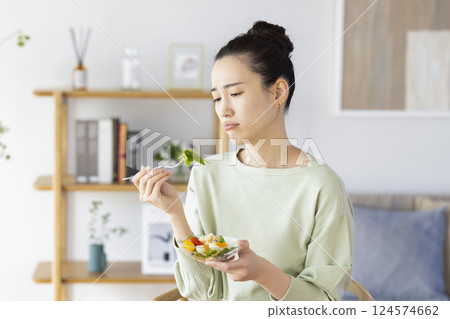 A woman who is tired of eating salad 124574662