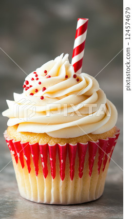 single cupcake with swirled frosting and striped straw single cupcake with swirled frosting and striped straw 124574679
