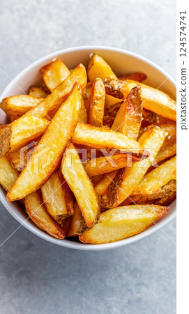 Bowl of crispy golden french fries on light background 124574741