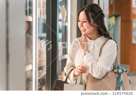 Business woman enjoying shopping looking at the products in the show window 124574826
