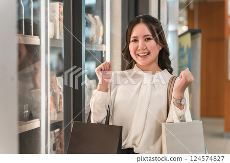 Business woman enjoying shopping looking at the products in the show window 124574827