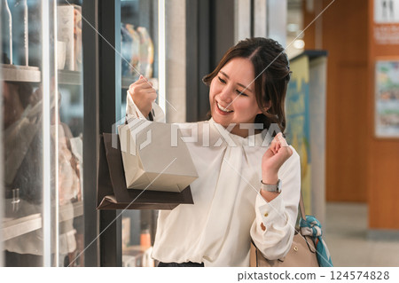 Business woman enjoying shopping looking at the products in the show window Business woman enjoying shopping looking at the products in the show window 124574828