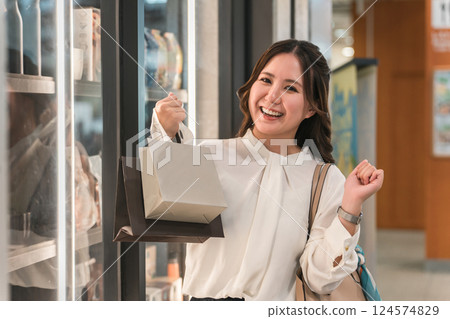 Business woman enjoying shopping looking at the products in the show window Business woman enjoying shopping looking at the products in the show window 124574829