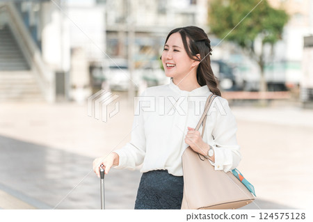 A businesswoman walking through a station on her way to work, commute, transfer, or business trip (on foot) 124575128