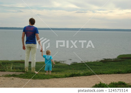 Father and Child Enjoying Scenic Lakeside View Father and Child Enjoying Scenic Lakeside View 124575514