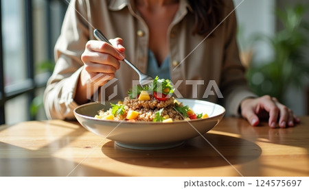 Enjoying a healthy meal with colorful vegetables and grains at a cozy restaurant during lunchtime 124575697