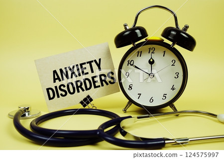 Anxiety Disorders text message on paper card with stethoscope and alarm clock on yellow background Anxiety Disorders text message on paper card with stethoscope and alarm clock on yellow background 124575997