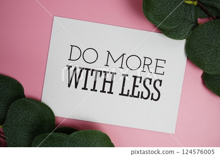Do More with Less Quote text on paper card top view on pink background, Motivation and inspirational concept 124576005