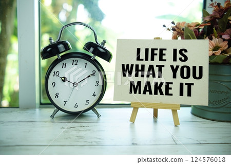 Life is what you make it text  motivational and inspiration quote with alarm clock on wooden background 124576018