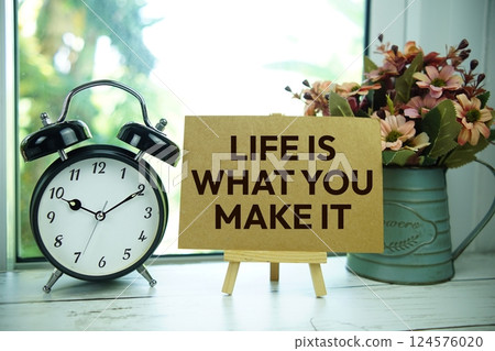 Life is what you make it text  motivational and inspiration quote with alarm clock on wooden background 124576020