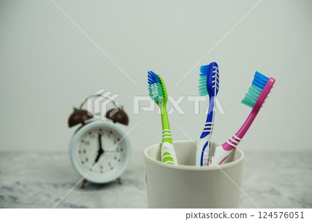 Toothbrush with alarm clock dental hygiene concept on marble background Toothbrush with alarm clock dental hygiene concept on marble background 124576051