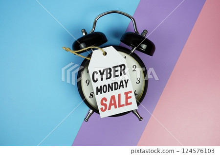 Cyber Monday Sale text on price tag with alarm clcok top view on green geometric background 124576103