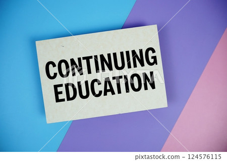 Continuing Education text on paper card on blue, purple, pink geometric background 124576115