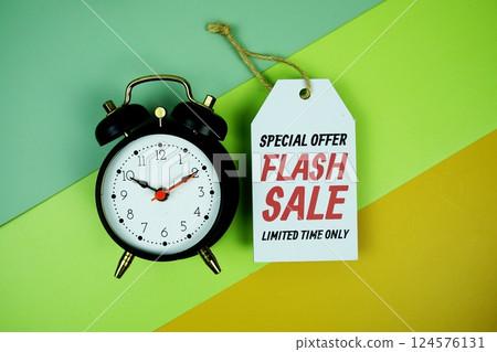 Flash Sale text on price tag with alarm clcok top view on green geometric background Flash Sale text on price tag with alarm clcok top view on green geometric background 124576131
