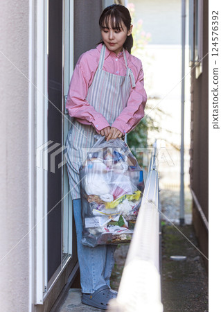 Housewife taking out the trash 124576392