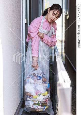 Housewife taking out the trash 124576398