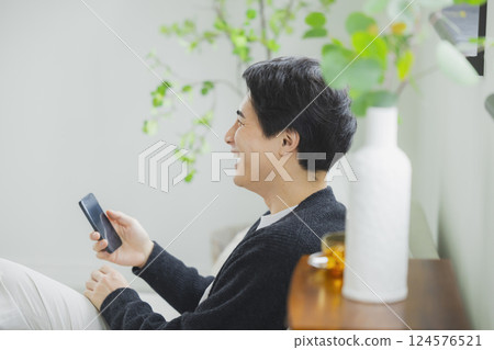 A man who uses a smartphone in the living room 124576521