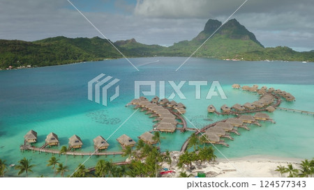 Stunning drone footage idyllic Bora Bora, overwater bungalows in turquoise waters and the dramatic backdrop of mount Otemanu, epitomizing French Polynesia's allure. Travel tropical vacation concept Stunning drone footage idyllic Bora Bora, overwater bungalows in turquoise waters and the dramatic backdrop of mount Otemanu, epitomizing French Polynesia's allure. Travel tropical vacation concept 124577343