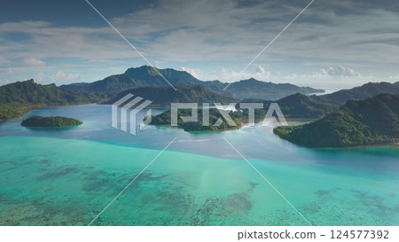Breathtaking aerial landscape, turquoise ocean water coastline with multiple lush green islands. Jungle rainforest mountains under blue sky, perfect wild nature travel background. Bora Bora lagoon 124577392