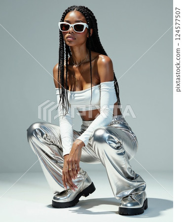 Futuristic fashion style: trendy metallic pants with chic white top and sunglasses 124577507