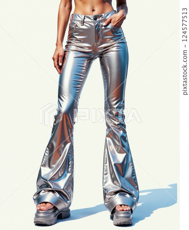 Futuristic silver metallic flare pants fashion statement with chunky platform shoes against minimalist backdrop Futuristic silver metallic flare pants fashion statement with chunky platform shoes against minimalist backdrop 124577513