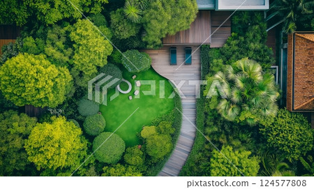 Beautiful tranquil garden with wooden deck, stone paths, and lush greenery 124577808