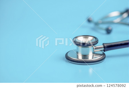 Medical stethoscope on blue background, essential healthcare tool for diagnostic purposes, used by doctors, nurses, and professionals in hospitals and clinic Medical stethoscope on blue background, essential healthcare tool for diagnostic purposes, used by doctors, nurses, and professionals in hospitals and clinic 124578092